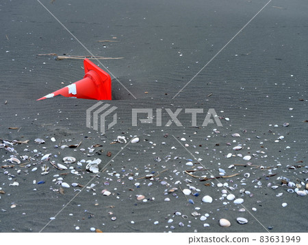 Red traffic cone launched on a sandy beach Red traffic cone launched on a sandy beach 83631949