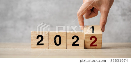 hand flipping block 2021 to 2022 text on table. Resolution, strategy, plan, goal, motivation, reboot, business and New Year holiday concepts 83631974