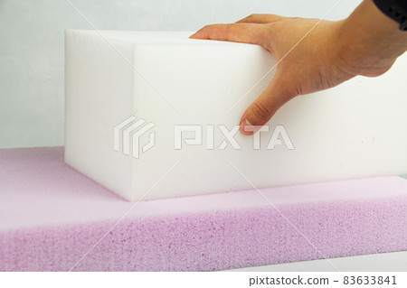 the hand presses on the surface of the rubber foam. Checking hardness and softness. Choosing the best type and quality. Close-up. the hand presses on the surface of the rubber foam. Checking hardness and softness. Choosing the best type and quality. Close-up. 83633841