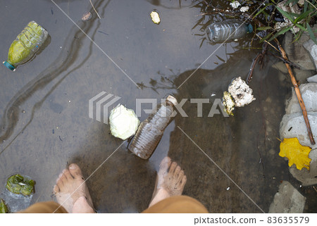 Legs of man standing barefoot or walking in flooded water on street flooding road risk of contagious disease and infection by contact with dirty water cause of itchy skin athlete foot or tine-a pedis 83635579