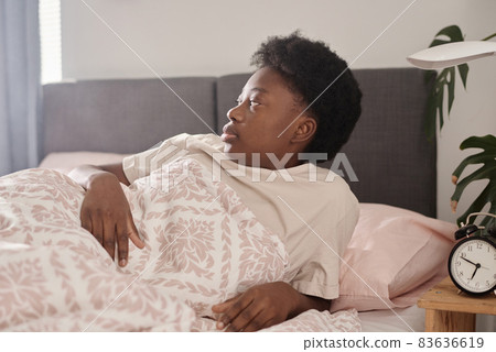African young woman getting up early in the morning after sleeping in her bedroom African young woman getting up early in the morning after sleeping in her bedroom 83636619