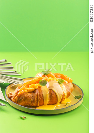 Croissant with salmon and avocado sauce on green Croissant with salmon and avocado sauce on green 83637383
