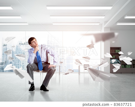 Young businessman sitting on an office chair Young businessman sitting on an office chair 83637721