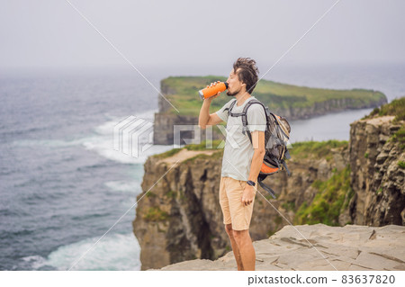 Male tourist on the background of beautiful rocks and the sea. Hiking concept. Tobizin cape. Vladivostok, island Russky. Sea of Japan. Primorye. Primorsky krai. Nature of Russia. Tourism and travel in Male tourist on the background of beautiful rocks and the sea. Hiking concept. Tobizin cape. Vladivostok, island Russky. Sea of Japan. Primorye. Primorsky krai. Nature of Russia. Tourism and travel in 83637820