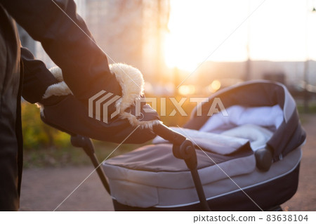 Mother strolling with newborn in carriage. Closeup shot Mother strolling with newborn in carriage. Closeup shot 83638104