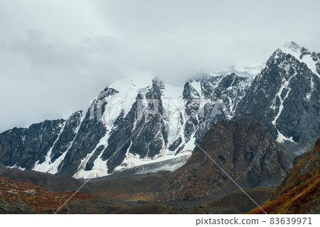 Minimalist atmospheric mountains landscape with big snowy mountain top in low clouds. Awesome minimal scenery with glacier on rocks. High mountain pinnacle with snow in clouds. Minimalist atmospheric mountains landscape with big snowy mountain top in low clouds. Awesome minimal scenery with glacier on rocks. High mountain pinnacle with snow in clouds. 83639971