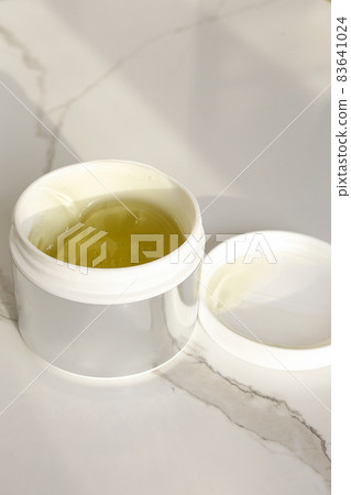 Cosmetic cream container with face or body cream on neutral background Cosmetic cream container with face or body cream on neutral background 83641024