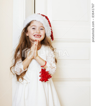 little cute girl in santas red hat waiting for Christmas gifts. holiday lifestyle people concept little cute girl in santas red hat waiting for Christmas gifts. holiday lifestyle people concept 83641787