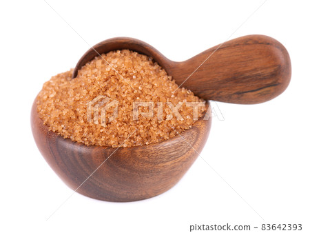 Brown sugar in wooden bowl and spoon, isolated on white background. Heap of cane sugar crystals. 83642393