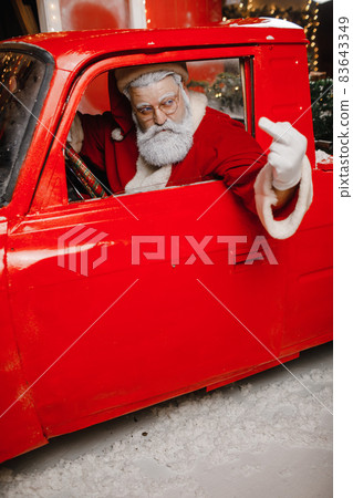 Santa Claus is preparing for Christmas. Angry, displeased, annoyed, stylish Santa Claus driving a Santa Claus is preparing for Christmas. Angry, displeased, annoyed, stylish Santa Claus driving a 83643349