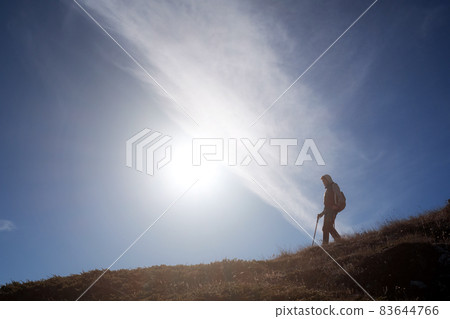 Young woman hiker with a backpack on the top of the mountain 83644766