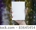 A woman holding white booklet 83645454