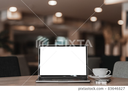 Mockup of laptop computer with empty screen with coffee cup and smartphone on table of the coffee shop background,White screen Mockup of laptop computer with empty screen with coffee cup and smartphone on table of the coffee shop background,White screen 83646827
