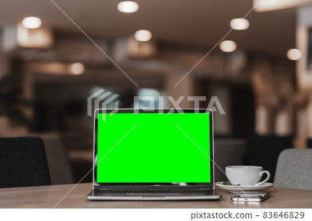 Mockup of laptop computer with empty screen with coffee cup and smartphone on table of the coffee shop background,Green screen Mockup of laptop computer with empty screen with coffee cup and smartphone on table of the coffee shop background,Green screen 83646829