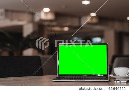 Mockup of laptop computer with empty screen with coffee cup and smartphone on table of the coffee shop background,Green screen Mockup of laptop computer with empty screen with coffee cup and smartphone on table of the coffee shop background,Green screen 83646831