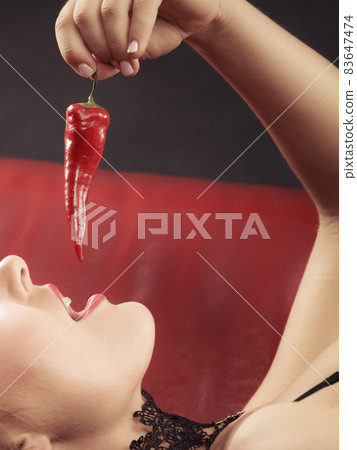 Woman wearing lingerie holding chilli pepper Stock Photo