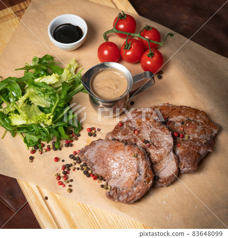 Fresh pork fillets served with lettuce salad with arugula-seeded pepper mixture and cherry tomatoes,. Restaurant concept. Restaurant food. Grill concept 83648099