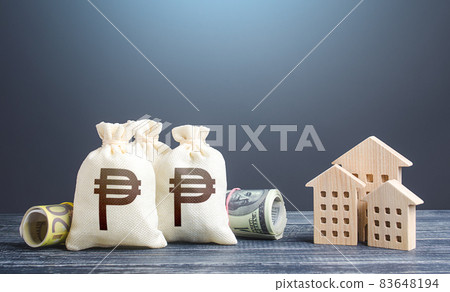Philippine peso money bags and residential buildings figures. Investments in real estate. Taxes. Mortgage loan. Financing the construction and renovation of housing. Municipal budget management. 83648194