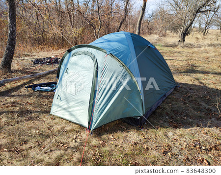 Camouflage tourist tent in autumn forest camp Camouflage tourist tent in autumn forest camp 83648300