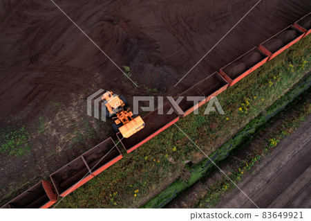 Wheel loader loads peat in freight cars.  83649921