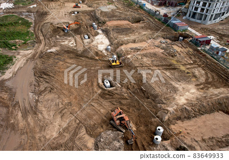 Laying a concrete well ring and sewer pipe at construction site. Earthworks Laying a concrete well ring and sewer pipe at construction site. Earthworks 83649933