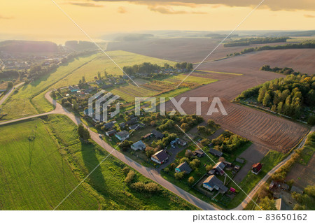 Country houses in the countryside. Aerial view of roofs of green field with rural homes. Country houses in the countryside. Aerial view of roofs of green field with rural homes. 83650162