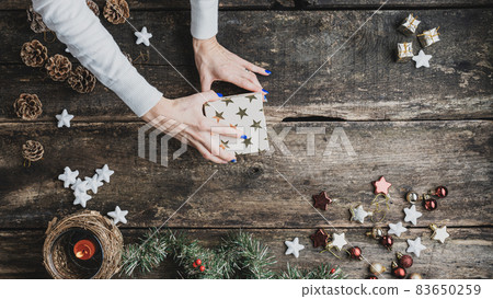 Female hand closing a holiday gift box 83650259