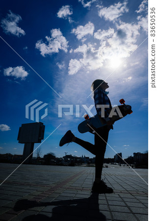 Beautiful young skater woman riding on her longboard in the city. 83650536