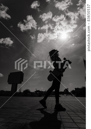 Beautiful young skater woman riding on her longboard in the city. 83650537
