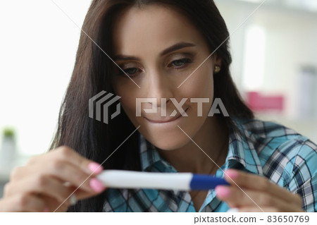 Woman squeezing lips looks test determine pregnancy Woman squeezing lips looks test determine pregnancy 83650769