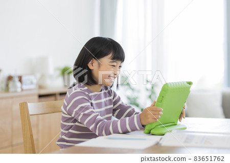 Girl elementary school student studying on a tablet PC 83651762