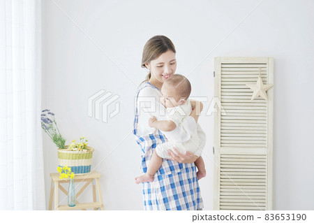 A woman holding a baby 83653190