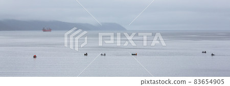 Fishermen in rubber boats are fishing in the sea bay 83654905