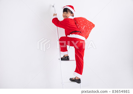 Girl dressed as Santa A girl dressed as Santa climbing a ladder Girl dressed as Santa A girl dressed as Santa climbing a ladder 83654981