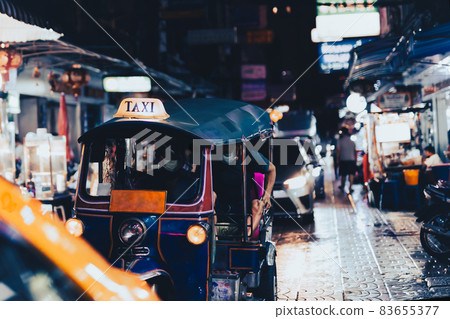 Famous Tuk Tuk with passengers at night market in Bangkok. 83655377