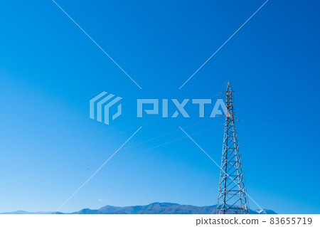 High-voltage power lines towering under the blue sky 83655719