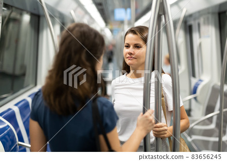 Two girlfriends talk in a subway car 83656245