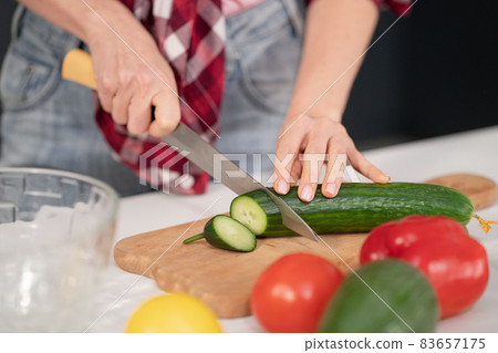 Close up. Young woman cutting ingredients on table cooking a lunch or dinner standing in the kitchen. Healthy food living. Healthy lifestyle 83657175