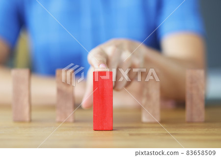 Female hand choosing red block among wooden closeup Female hand choosing red block among wooden closeup 83658509