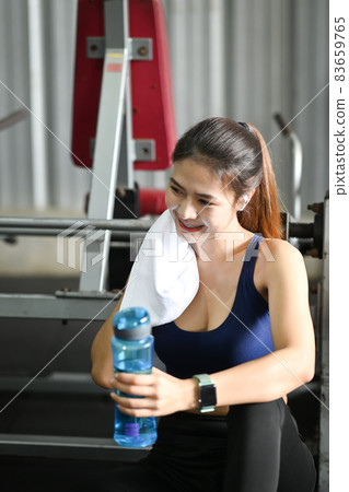 Sport woman drinking water while taking a break from workout in fitness gym. Sport woman drinking water while taking a break from workout in fitness gym. 83659765