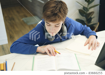 Student boy with tablet computer learning at home. 83660255