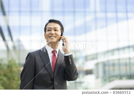 50多歲的商人用智能手機交談拍攝合作“LINK FOREST” 83660551