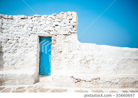 The narrow streets of the island with blue balconies, stairs and flowers in Greece. 83660697