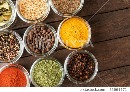 Colourful spices in bowls on wooden table. Big collection of spices. Top view 83661571
