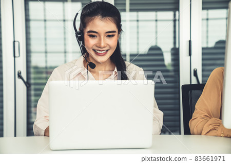 Businesswoman wearing headset working actively in office Businesswoman wearing headset working actively in office 83661971