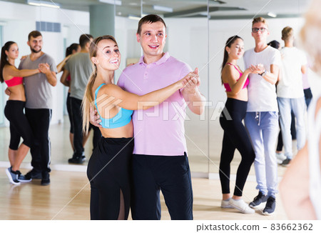 Dancing couples learning salsa at dance class 83662362