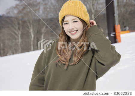 Snowboarder woman wearing a knit hat at a ski resort Spring ski image 83662828