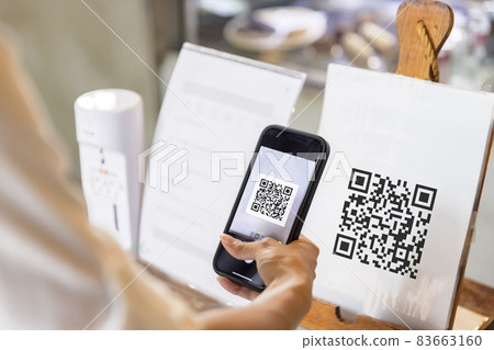 Hand of woman using the smartphone to scan QR code Hand of woman using the smartphone to scan QR code 83663160