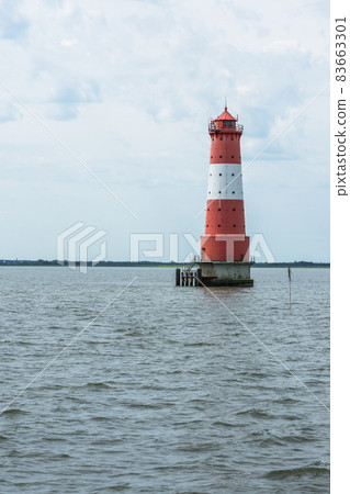 Lighthouse standing in water against sky, Jade Bight, Lower Saxony, Germany 83663301