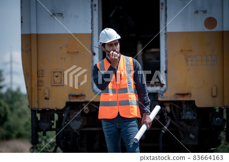 Engineer under discussion inspection and checking construction process railway switch and checking work on railroad station .Engineer wearing safety uniform and safety helmet in work. Engineer under discussion inspection and checking construction process railway switch and checking work on railroad station .Engineer wearing safety uniform and safety helmet in work. 83664163